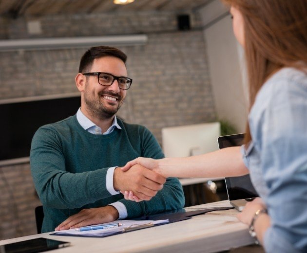 Oral surgery team member greeting patient at reception desk