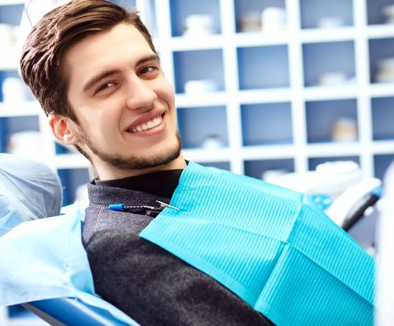 Male dental patient reclined in treatment chair