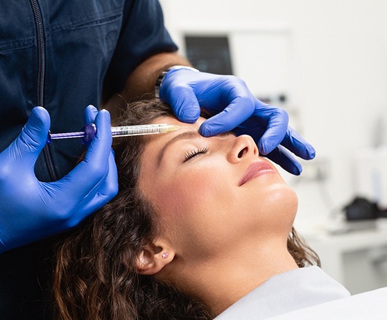 Woman lying back in chair for cosmetic BOTOX in Burke, VA