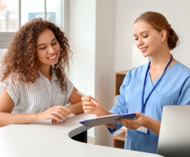 Oral surgery team member helping patient with insurance forms