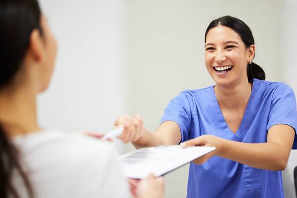 Dentist handing a patient dental insurance forms