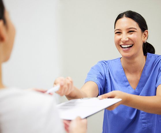 Patient with dental receptionist filling out paperwork