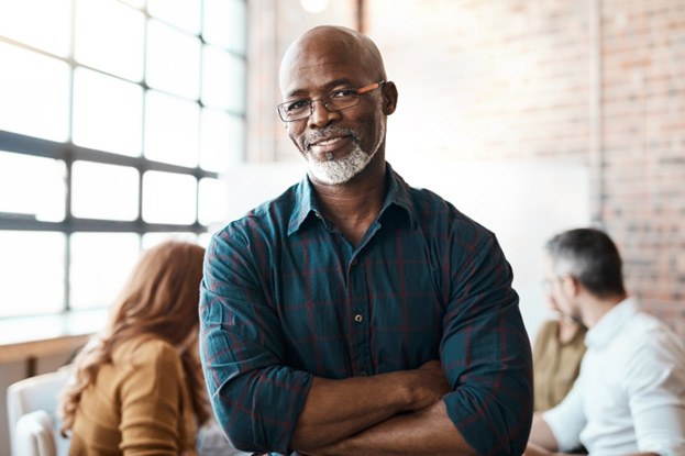 Smiling older man standing with his arms crossed