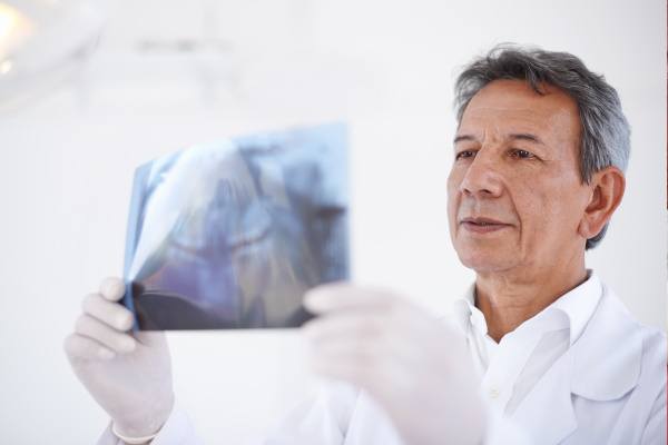 An oral surgeon reviewing an X-ray