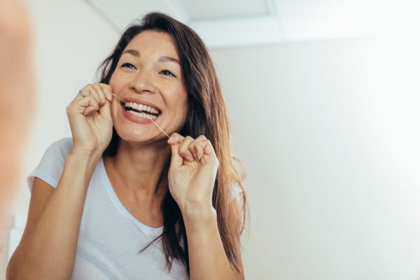 A woman flossing her teeth