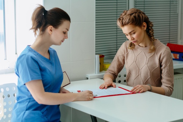 A dental assistant walking a patient through a treatment cost estimate