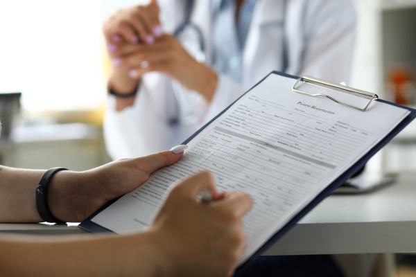 A patient filling out forms at a dental office