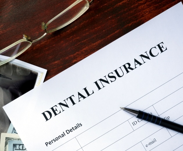 Dental insurance form in Burke on dark wood table