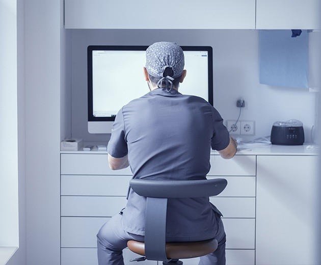 Oral surgeon typing on computer