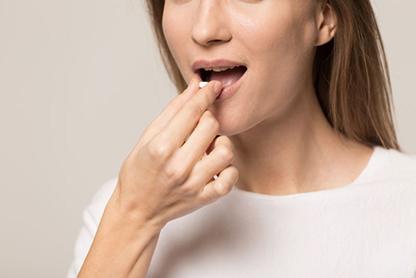 Woman preparing to swallow oral conscious sedation pill