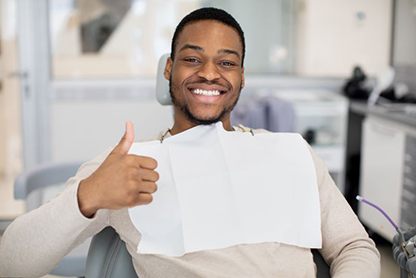 Smiling dental patient making thumbs up gesture