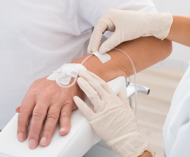 Patient with general anesthesia tubing attached to their arm