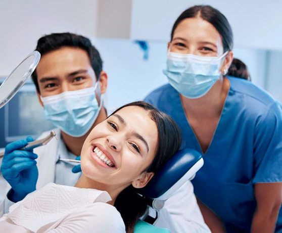 Happy patient smiling with dental team