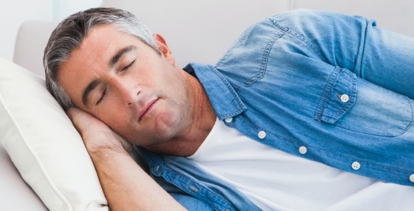 Man in denim shirt sleeping on his side