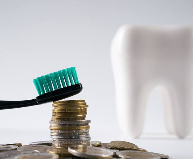 Coins next to a model tooth